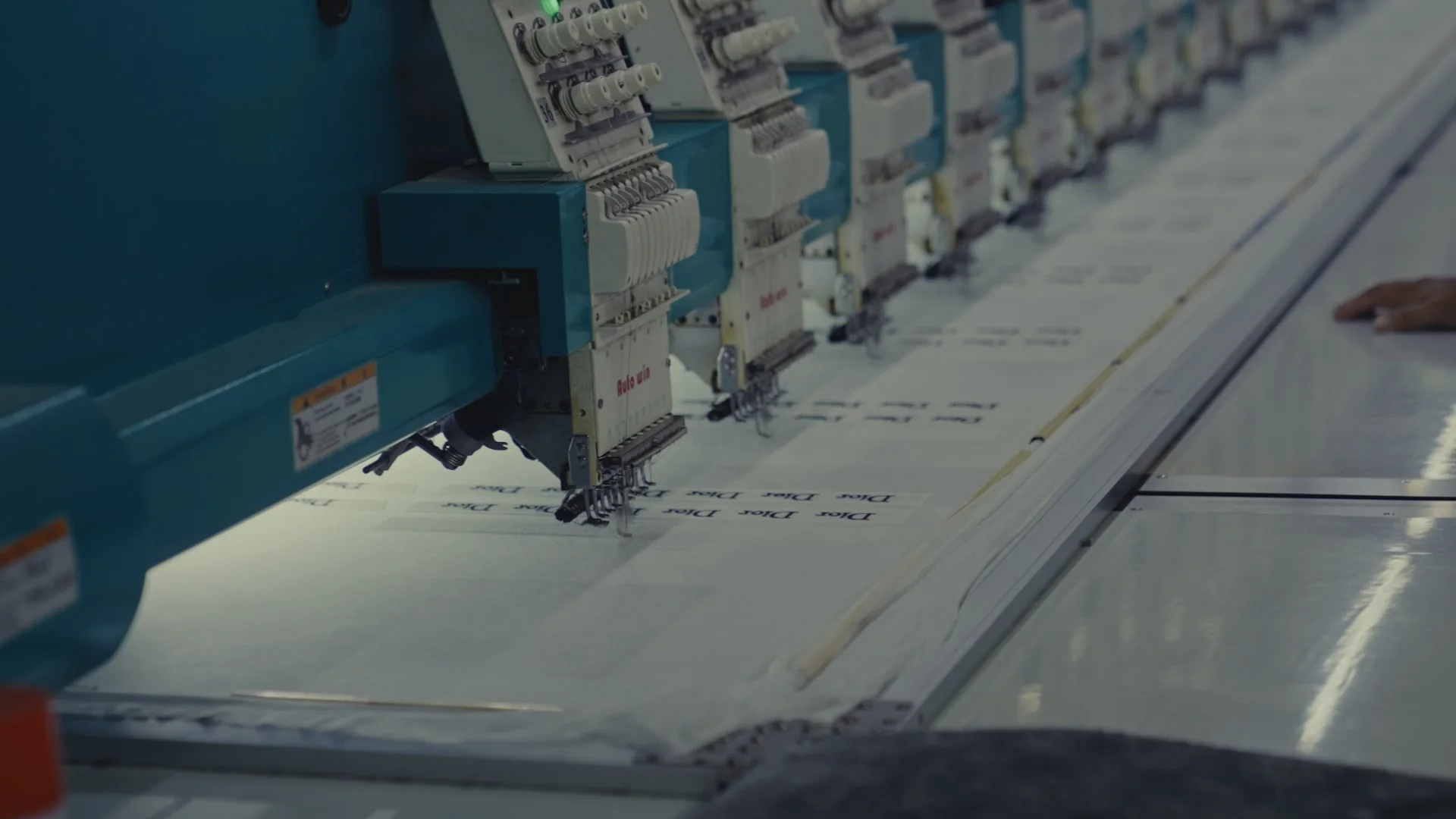 Multi-head embroidery machines stitching a bulk production run