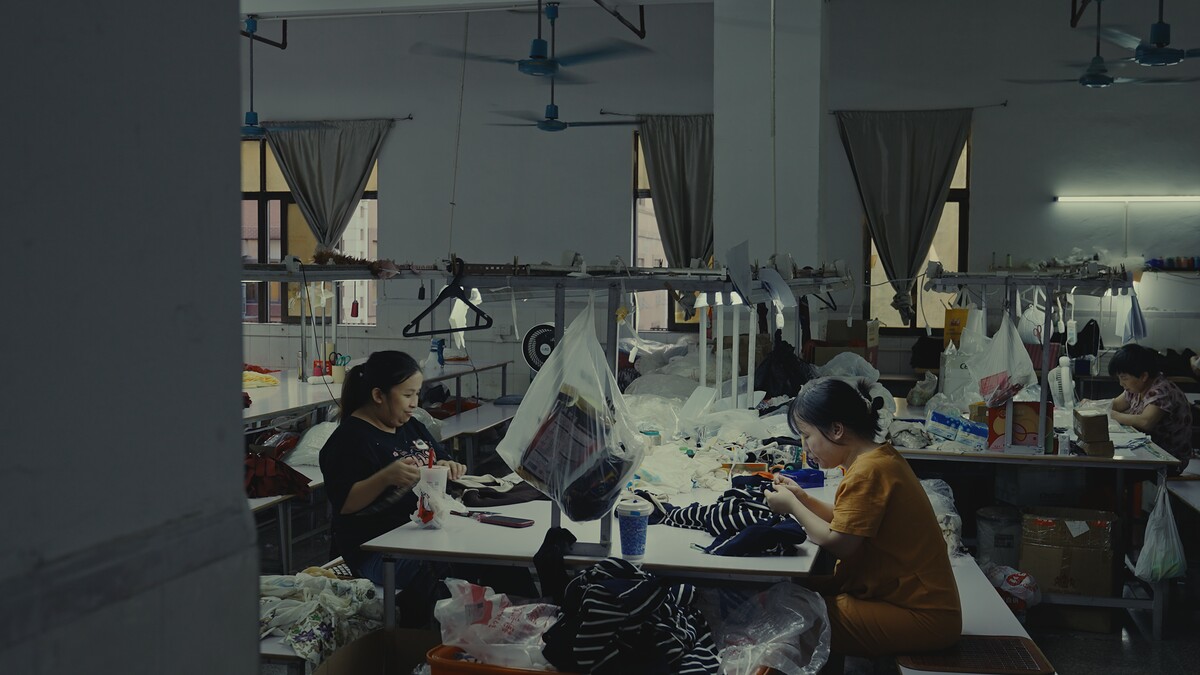 Inspector checking a garment and trimming loose threads