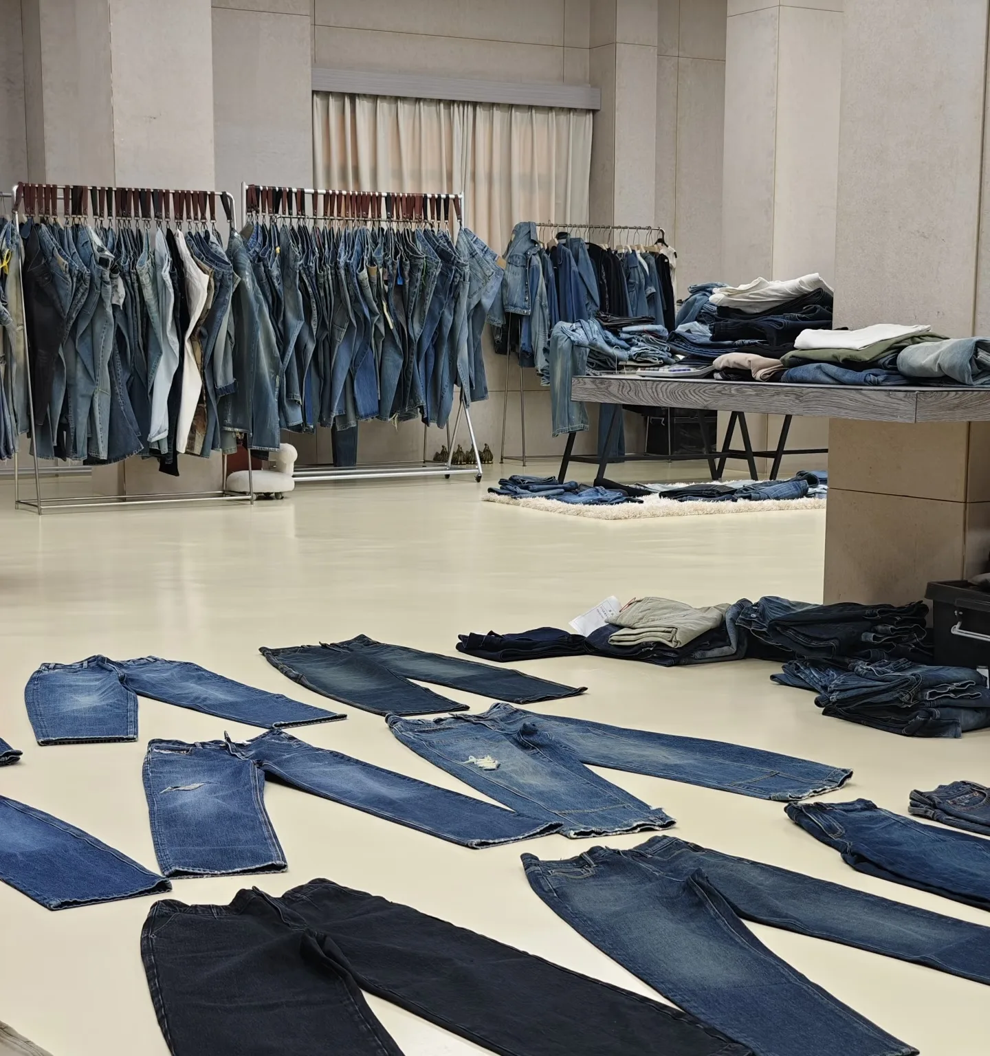 Denim styles laid out for on-site quality inspection at a Guangzhou wholesale sourcing floor
