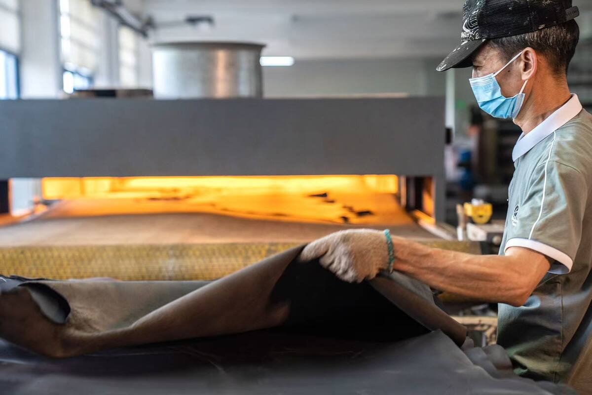 Operator trimming leather in the production line