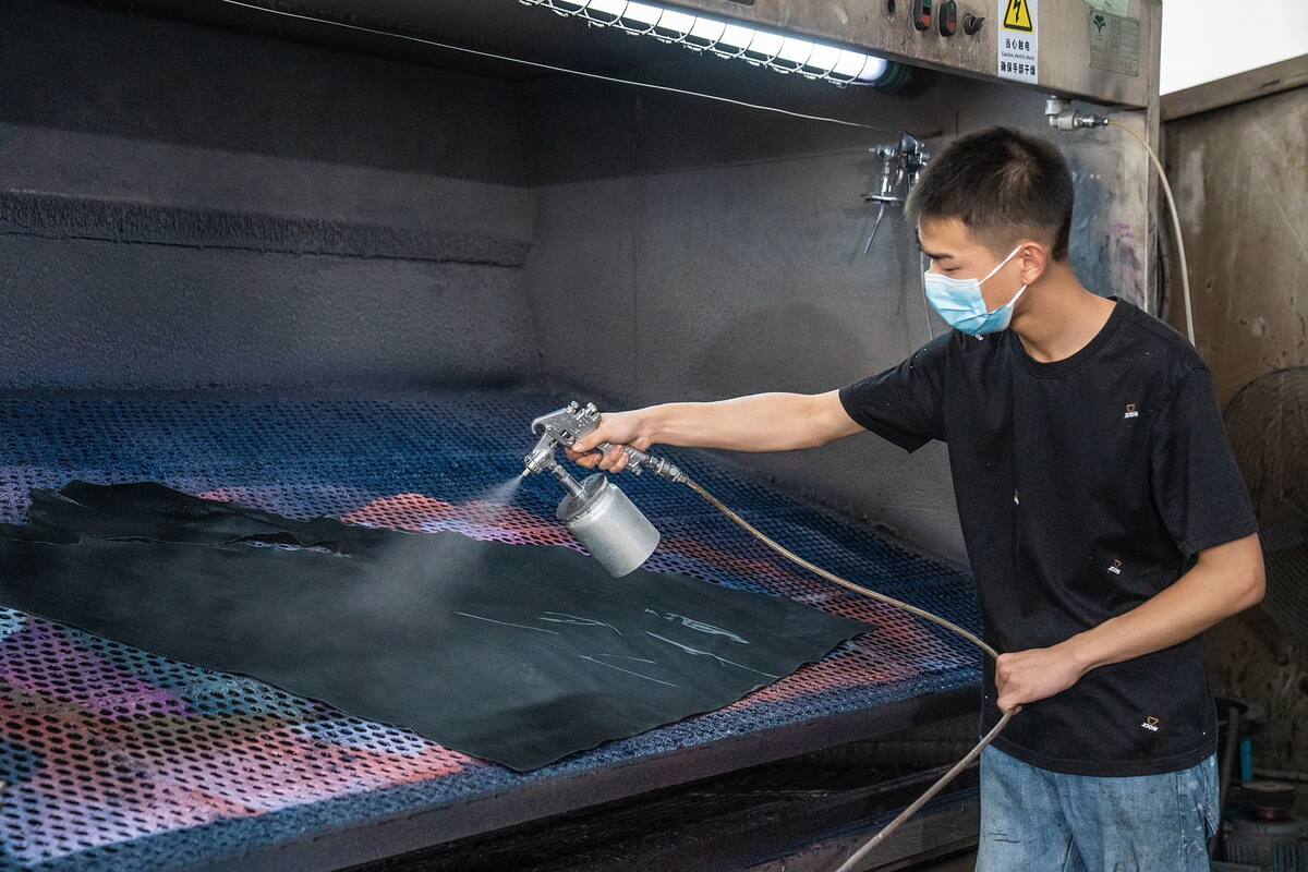 Technician applying a surface finish to leather