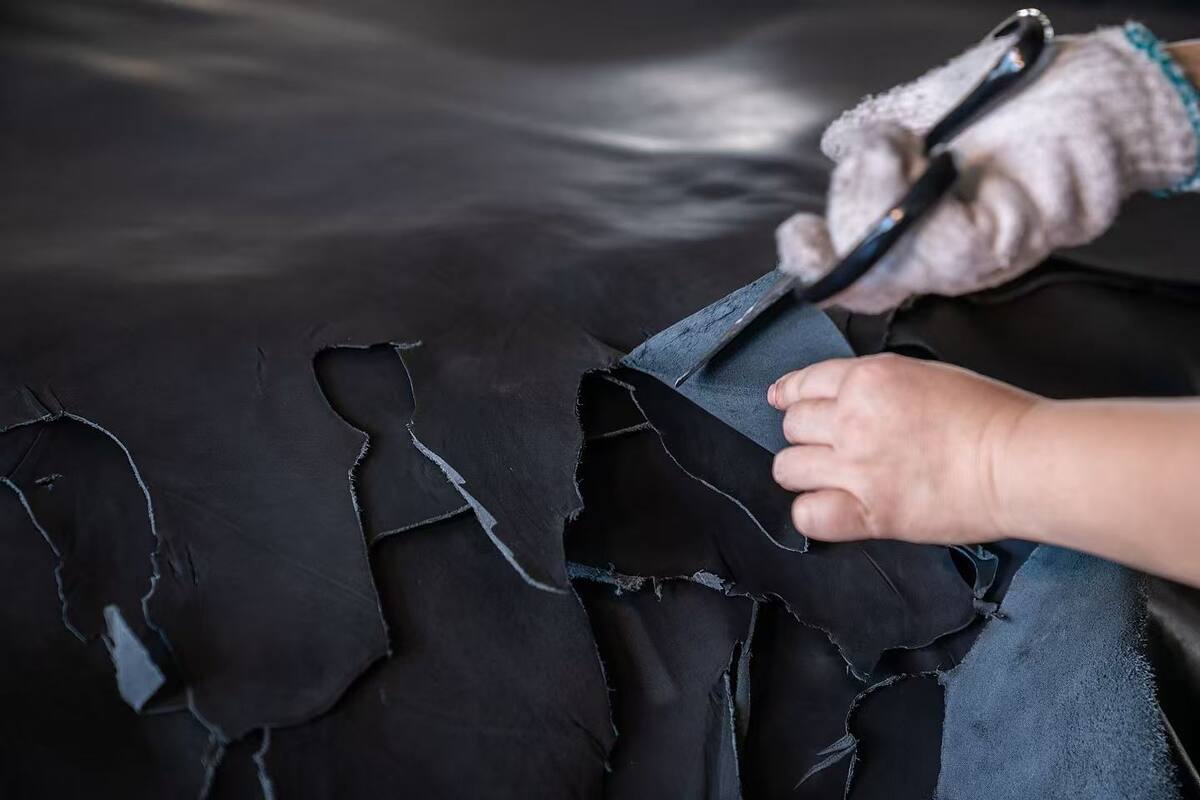 Craftsperson inspecting a finished black leather hide